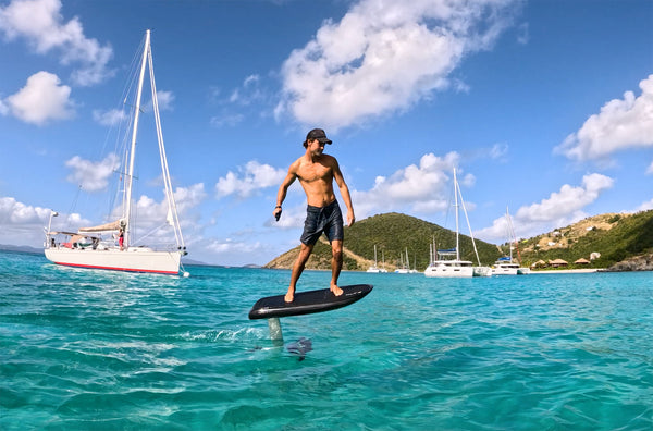 James Jenkins riding a Fliteboard ULTRA near a yacht in the British Virgin Islands